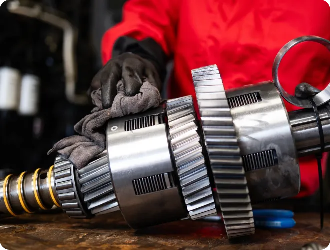 Person cleaning mechanical transmission parts