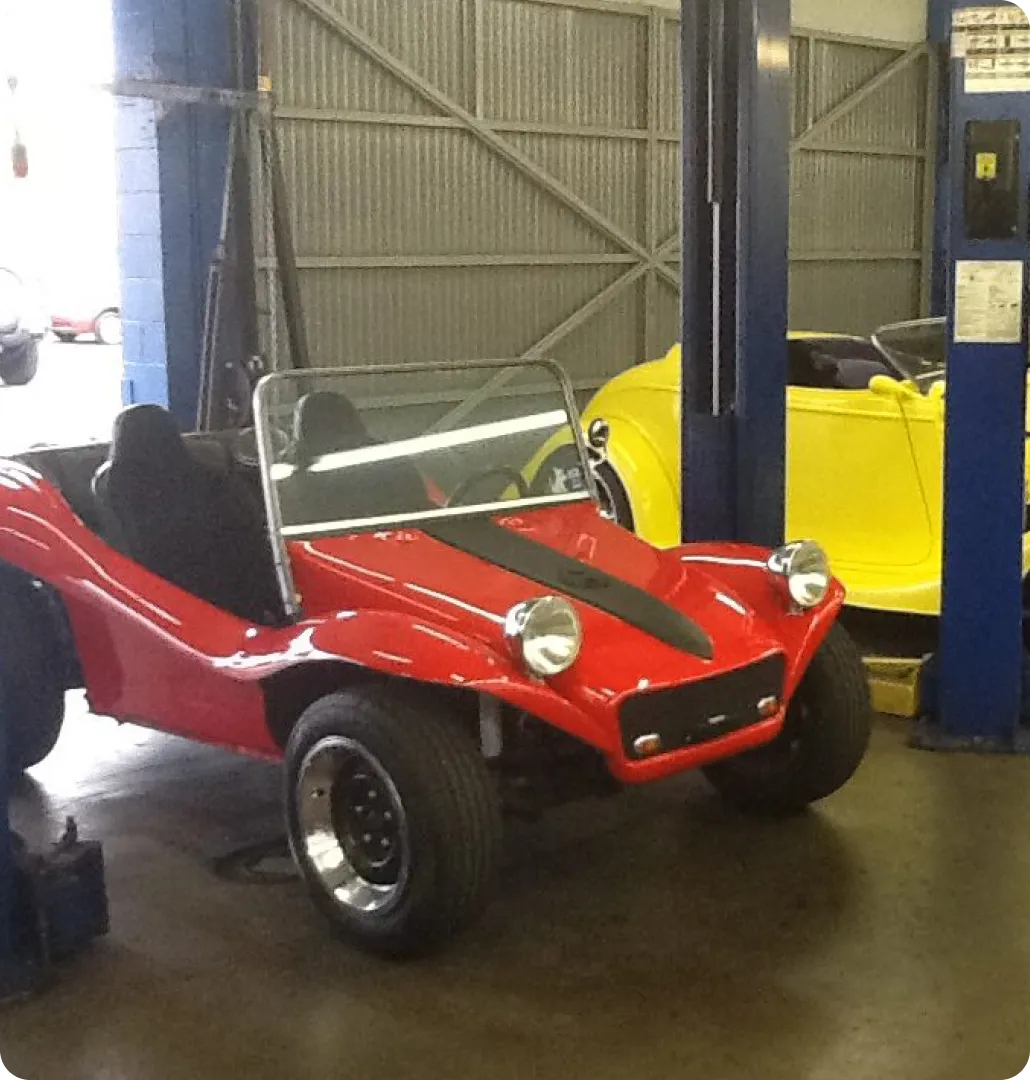 Two colorful vintage-style cars in garage